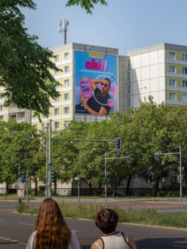 City building with large colorful billboard advertising chill brand.